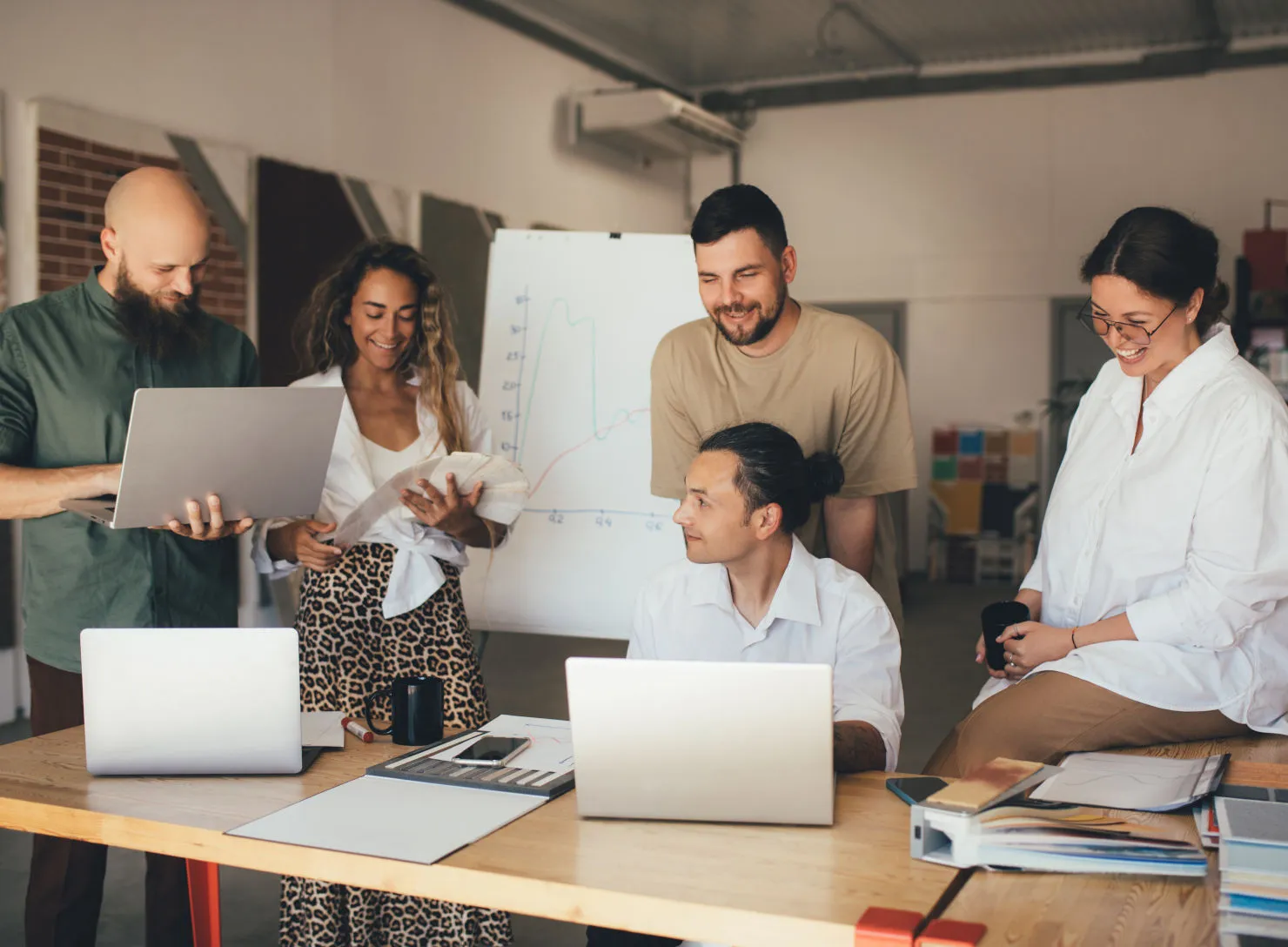 A team collaborating around laptops in a modern office