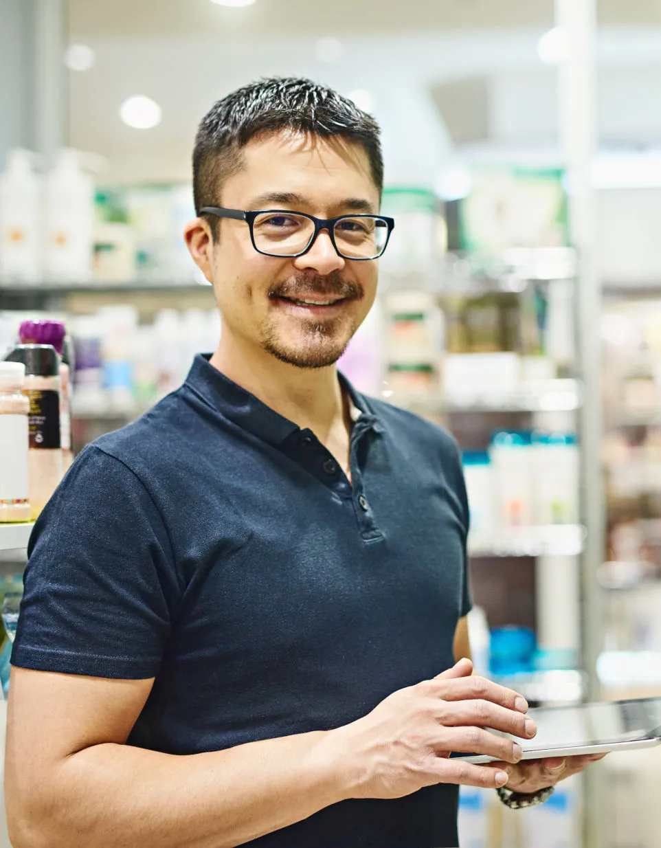 A Sempro maintenance technician holding a tablet in a store