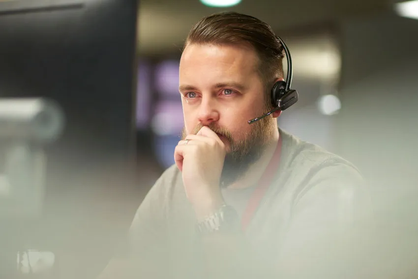 A Sempro support agent wearing a headset at a workstation
